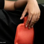 Person holding the red bag on the body