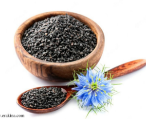 A bowl and spoon containing small black seeds and a blue flower