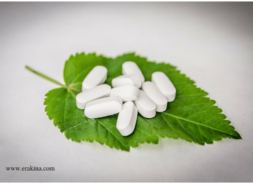 White rod-shaped pills on a green leaf