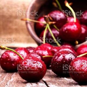 Cherries on wooden table with water drops